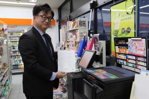 コンビニでサービスを利用する按田町長