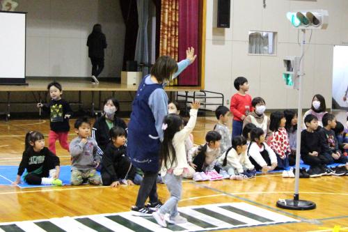 先生と手をつないで信号を渡る子ども